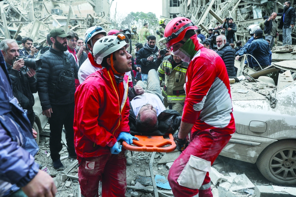 Emergency personnel work at the site of a strike on a residential building, in Tehran. — Reuters