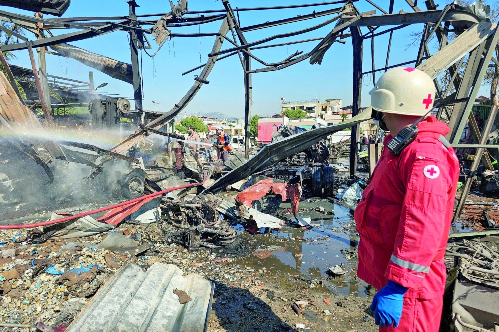 Firefighters and first responders work at the site of an air strike, in Beirut. — AFP