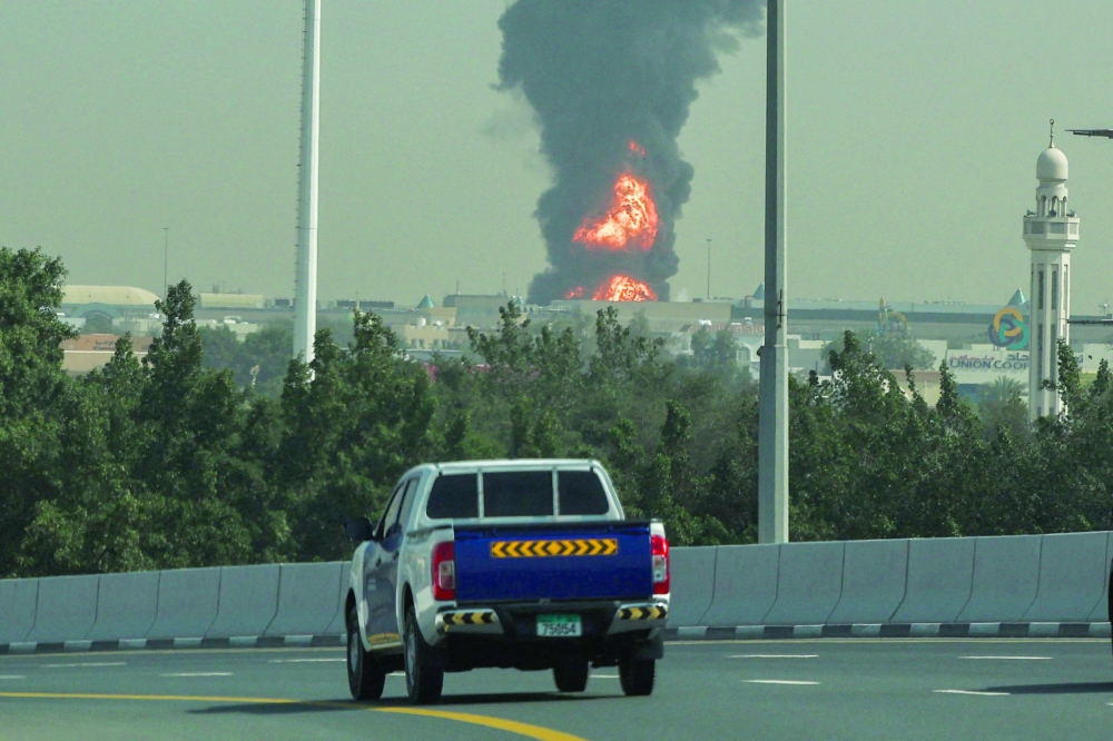 A smoke plume rises from an ongoing fire near Dubai International Airport. — AFP