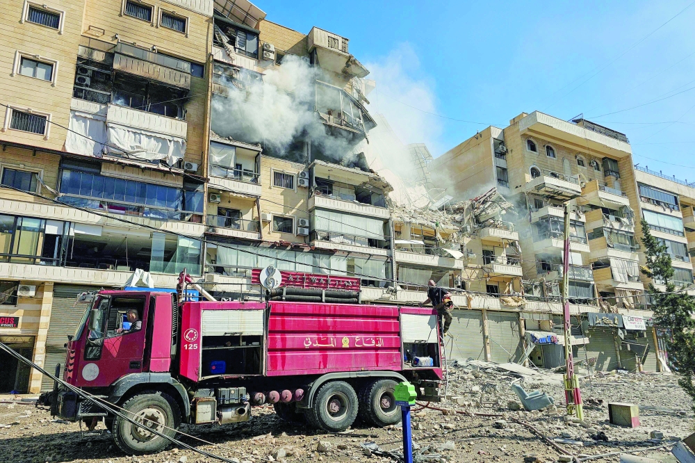 Firefighters work at the site of an Israeli air strike in the southern suburbs of Beirut. — AFP