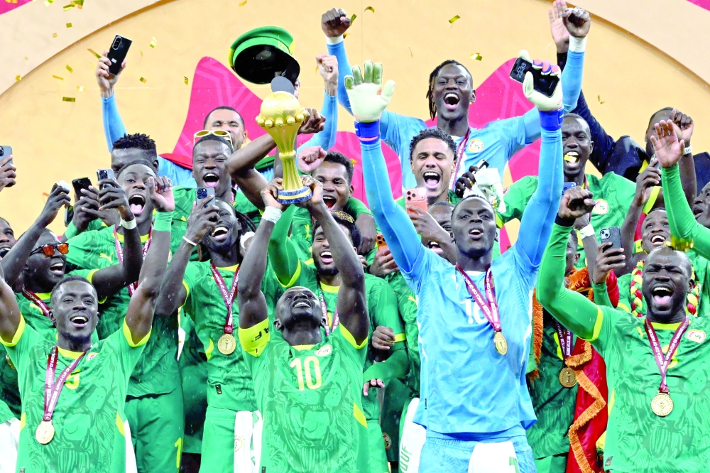 Senegal's forward #10 Sadio Mane holds up the trophy as he celebrates with his teammates after winning the Africa Cup of Nations (CAN) final football match against Morocco at the Prince Moulay Abdellah Stadium in Rabat on January 18, 2026. Senegal was stripped of its Africa Cup of Nations title by the Confederation of African Football (CAF) over its players' walk-off during the final, with Morocco declared champions, CAF announced on March 17, 2026. CAF confirmed the appeal by the Royal Moroccan Football Federation was upheld, overturning the earlier CAF Disciplinary Board decision that had allowed Senegal to keep their victory. (Photo by SEBASTIEN BOZON / AFP)