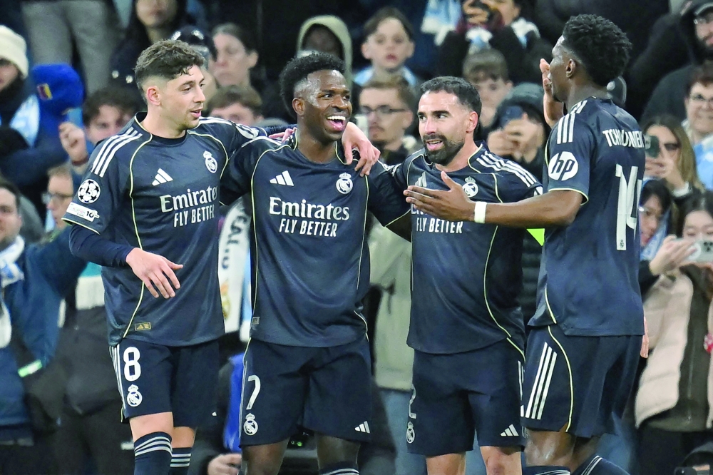 Real Madrid's Brazilian forward #07 Vinicius Junior (2L) celebrates after scoring their late second goal during the UEFA Champions League, round of 16 second leg football match between Manchester City and Real Madrid at the Etihad Stadium in Manchester, north west England, on March 17, 2026. (Photo by Paul ELLIS / AFP)
