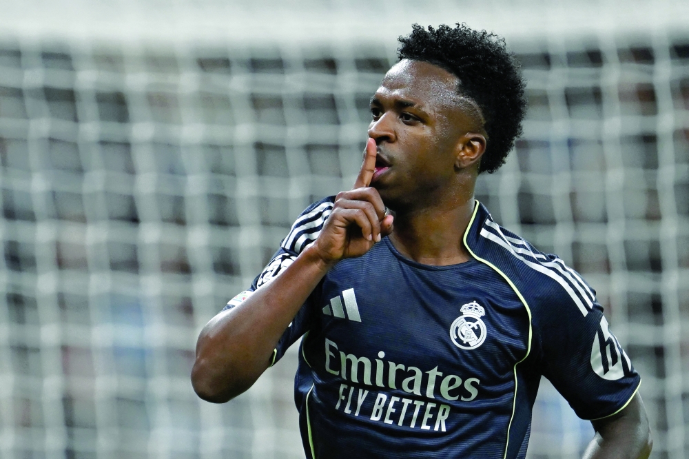 Real Madrid's Brazilian forward #07 Vinicius Junior celebrates scoring the opening goal during the UEFA Champions League, round of 16 second leg football match between Manchester City and Real Madrid at the Etihad Stadium in Manchester, north west England, on March 17, 2026. (Photo by Paul ELLIS / AFP)
