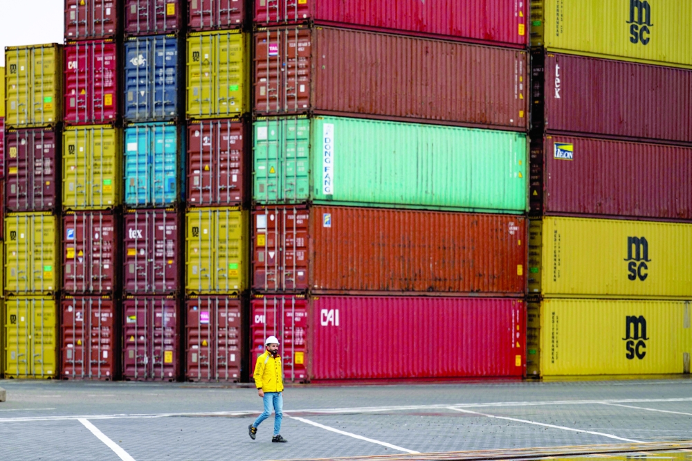 A dock worker walks past stacked shipping containers at Umm Qasr Port in Basra — AFP