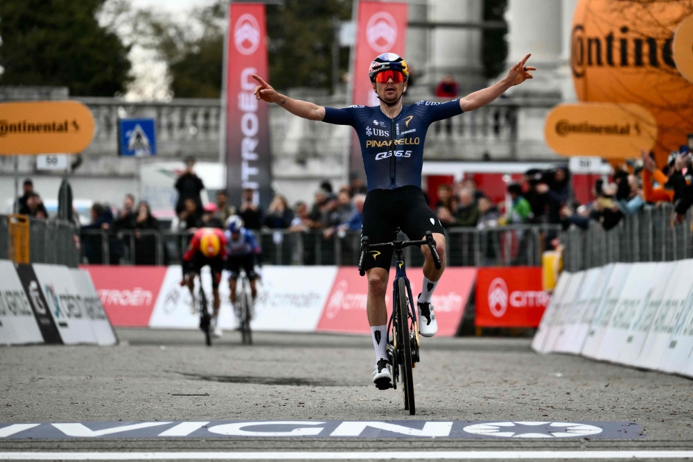 British Tom Pidcock celebrates as he crosses the finish line to win the Milano-Torino 2026 cycling race 