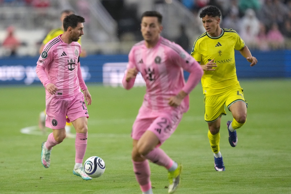 Inter Miami forward Lionel Messi (10) brings the ball up the field as Nashville SC defender Jeisson Palacios (4) follows on the play 
