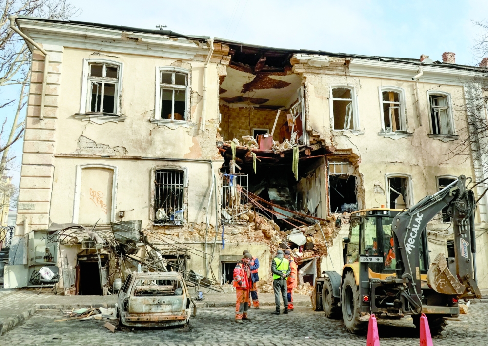 Communal workers clean an area at the site of an apartment building hit by a Russian drone strike, in Odesa, Ukraine. — Reuters 