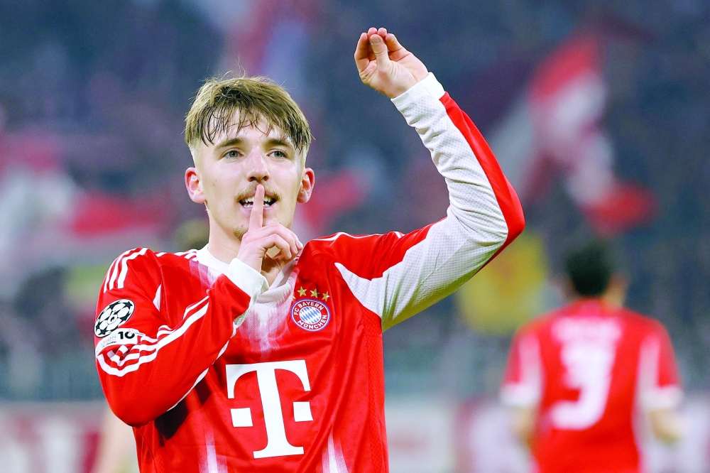 Bayern Munich's German midfielder #42 Lennart Karl celebrates scoring the 3-0 goal with his teammates during the UEFA Champions League, Round of 16 2nd-leg football match between FC Bayern Munich and Atalanta in Munich, southern Germany, on March 18, 2026.  (Photo by Alexandra BEIER / AFP)
