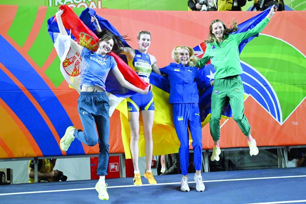 Gold medallist Ukraine's Yaroslava Mahuchikh (2ndL) celebrates with silver medallists Serbia's Angelina Topic (L), Ukraine's Yuliia Levchenko and Australia's Nicola Olyslagers after the women's final high jump event during the World Athletics Indoor Championships Kujawy Pomorze 2026 in Torun, Poland on March 20, 2026. (Photo by Kirill KUDRYAVTSEV / AFP)
