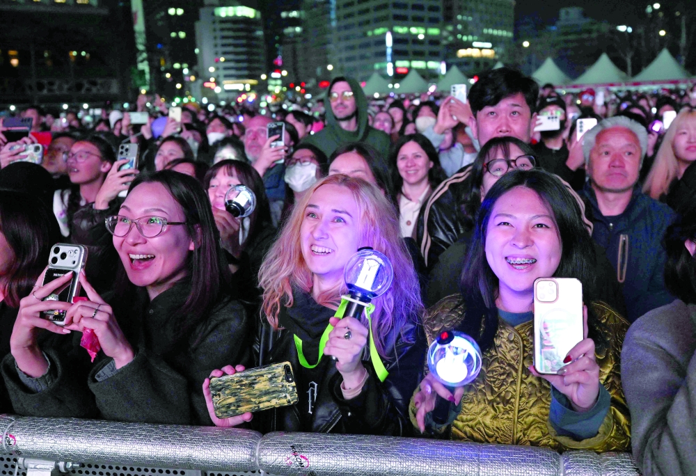 BTS fans react as they watch the comeback concert of K-pop boy group BTS on a screen at the venue in Seoul. — AFP