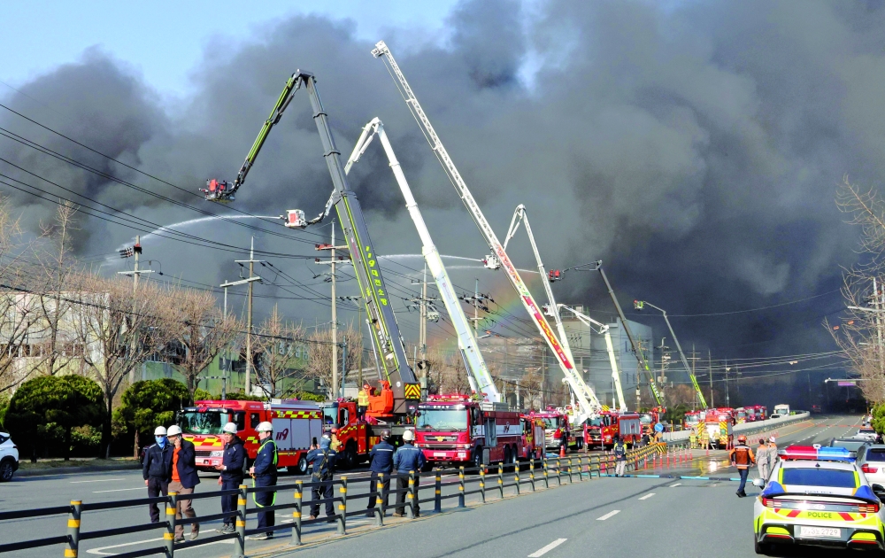 Firefighters spray water to extinguish a fire at a car parts plant in Daejeon. — AFP