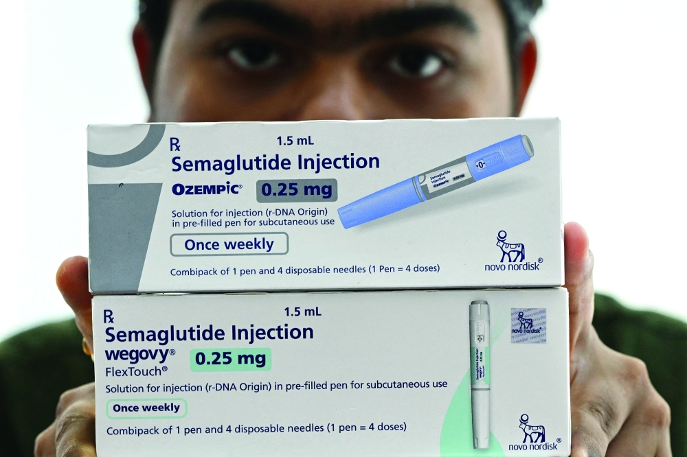 A medicine distributor displays packs of Ozempic and Wegovy self-injecting (semaglutide) GLP-1 prefilled pens at his office in Thane. — AFP