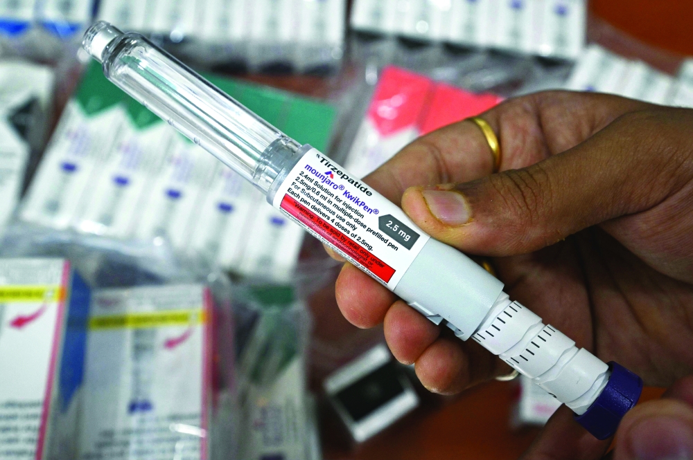 A medicine distributor displays Mounjaro (tirzepatide) self-injecting GLP-1 prefilled pens at his office in Thane. — AFP