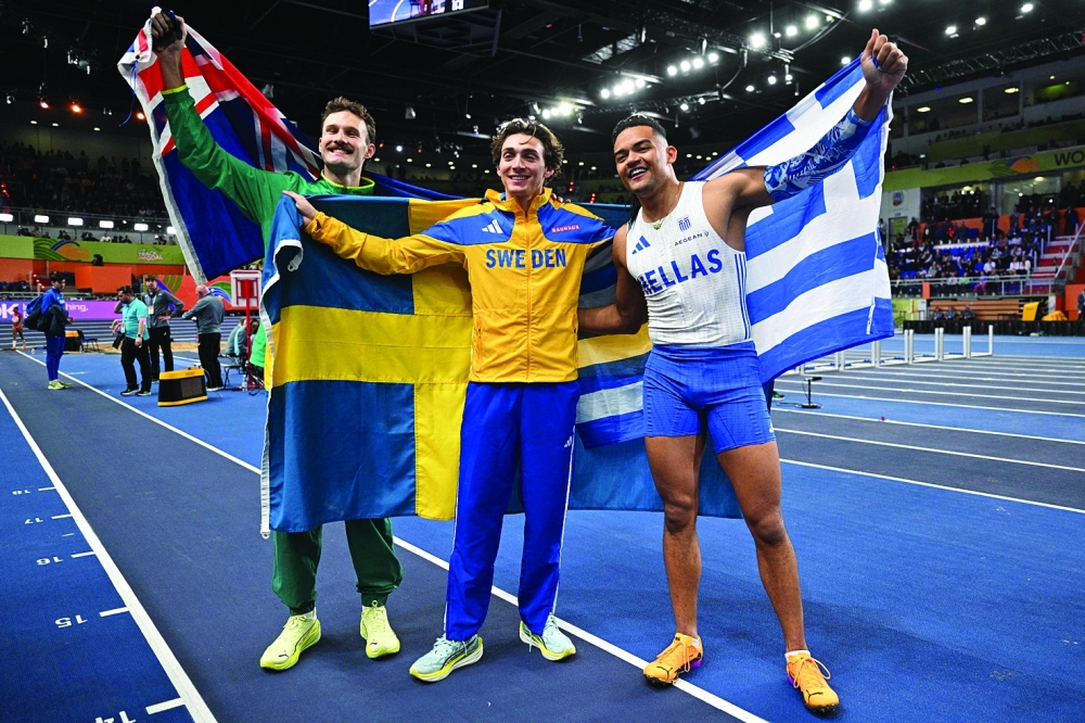 First placed Sweden's Armand Duplantis (C) celebrates with third placed Australia's Kurtis Marschall (L) and second placed Greece's Emmanouil Karalis after winning the men's pole vault final during the World Athletics Indoor Championships Kujawy Pomorze 2026 in Torun, Poland on March 21, 2026. (Photo by Andrej ISAKOVIC / AFP)

