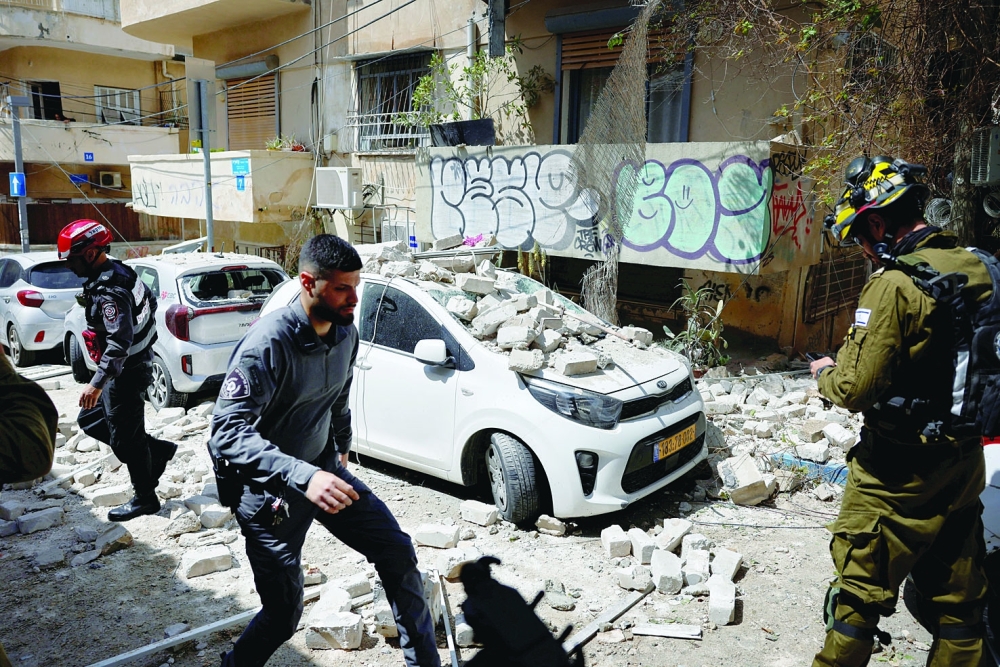 Security personnel work at the site of a damaged building in Tel Aviv on Sunday, — AFP