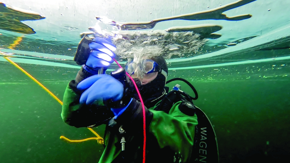 A participant in the Polar Scientific Diving programme takes ice samples during a 45-minute-long diving session, at the Kilpisjaervi Biological Station in Finland.