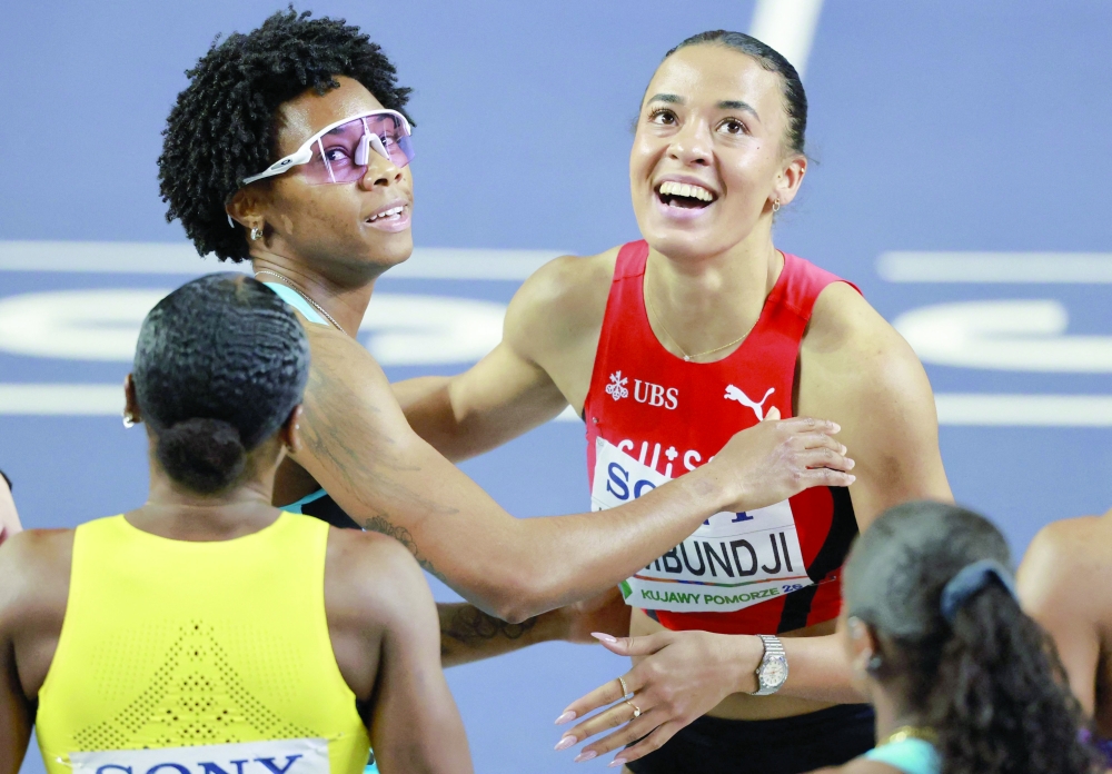 First placed Bahamas' Devynne Charlton (L) and Switzerland's Ditaji Kambundji celebrate after the women's final 60 metres hurdles event. — AFP