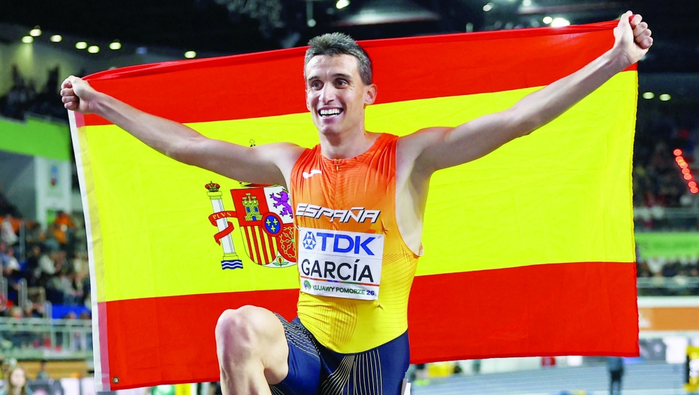 Spain's Mariano Garcia celebrates with his national flag after winning gold in the men's 1500m final. — Reuters