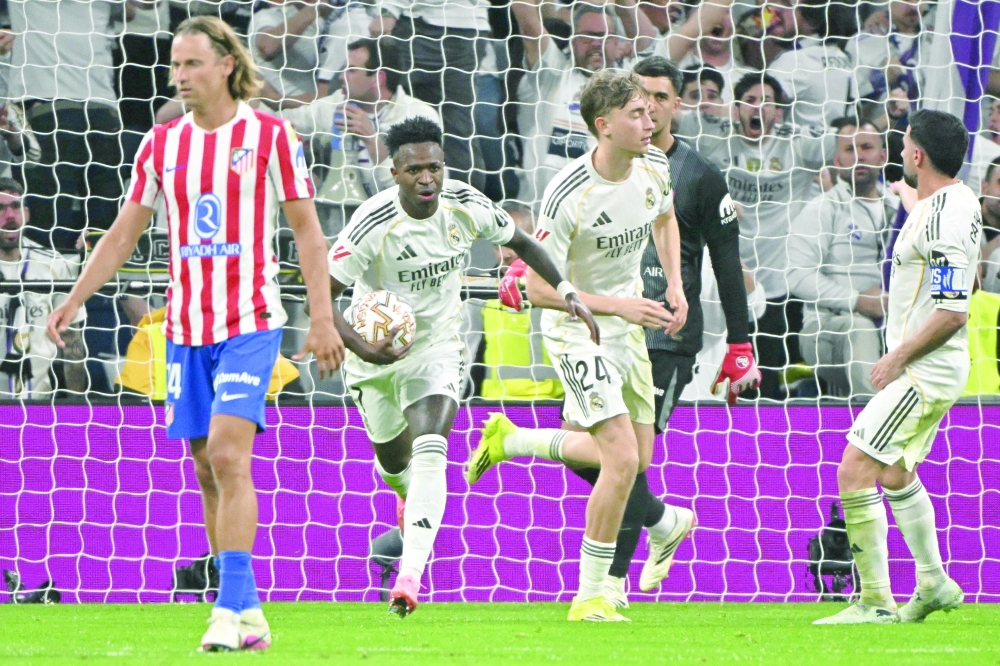 Real Madrid's Brazilian forward #07 Vinicius Junior (2L) celebrates scoring his team's first goal during the Spanish league football match between Real Madrid CF and Club Atletico de Madrid at Santiago Bernabeu Stadium in Madrid on March 22, 2026. (Photo by Javier SORIANO / AFP)
