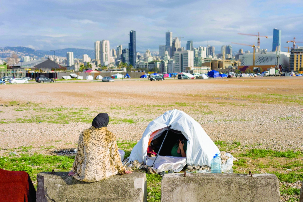 
A displaced woman sits next to her tent in a camp erected along the Beirut seafront area. — AFP 