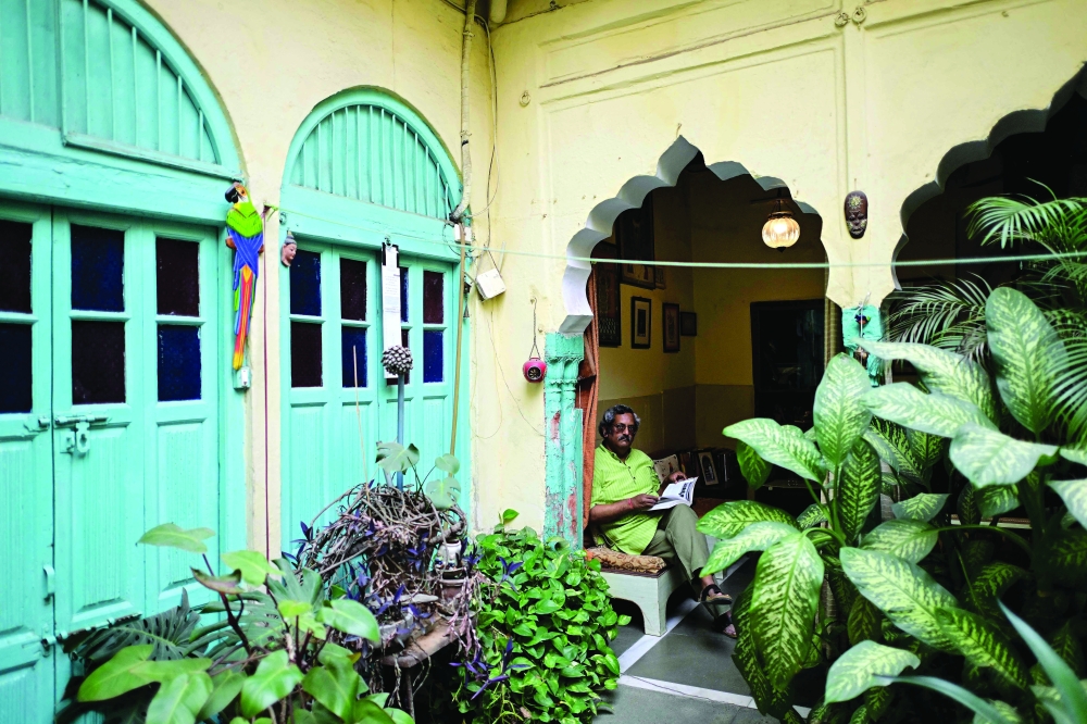 A resident reading a book at his century-old ancestral property Mathur ki Haveli in the old quarters of Delhi. — AFP