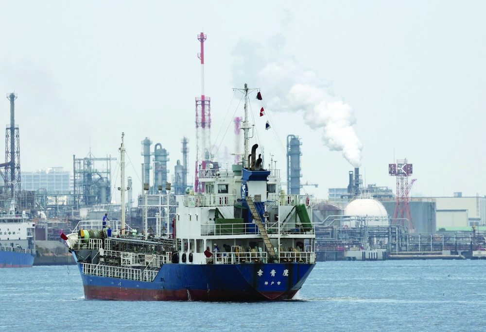 A small tanker sails near an oil refinery, in the Keihin Industrial Zone in Kawasaki, south of Tokyo, Japan. — Reuters