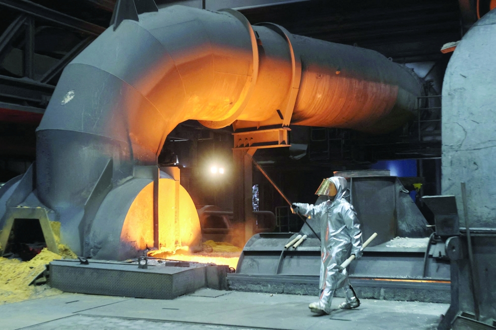 A steel worker of ThyssenKrupp walks in front of a blast furnace at a ThyssenKrupp steel factory in Duisburg, western Germany. — Reuters