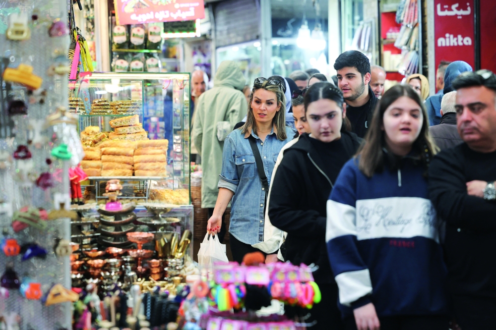 Iranian people walk at Tajrish Bazaar in Tehran, Iran, on Tuesday. — Reuters