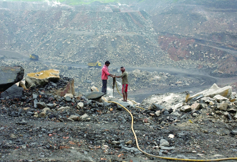 Workers drill at an open cast coal field at Dhanbad district in the eastern Indian state of Jharkhand. — Reuters