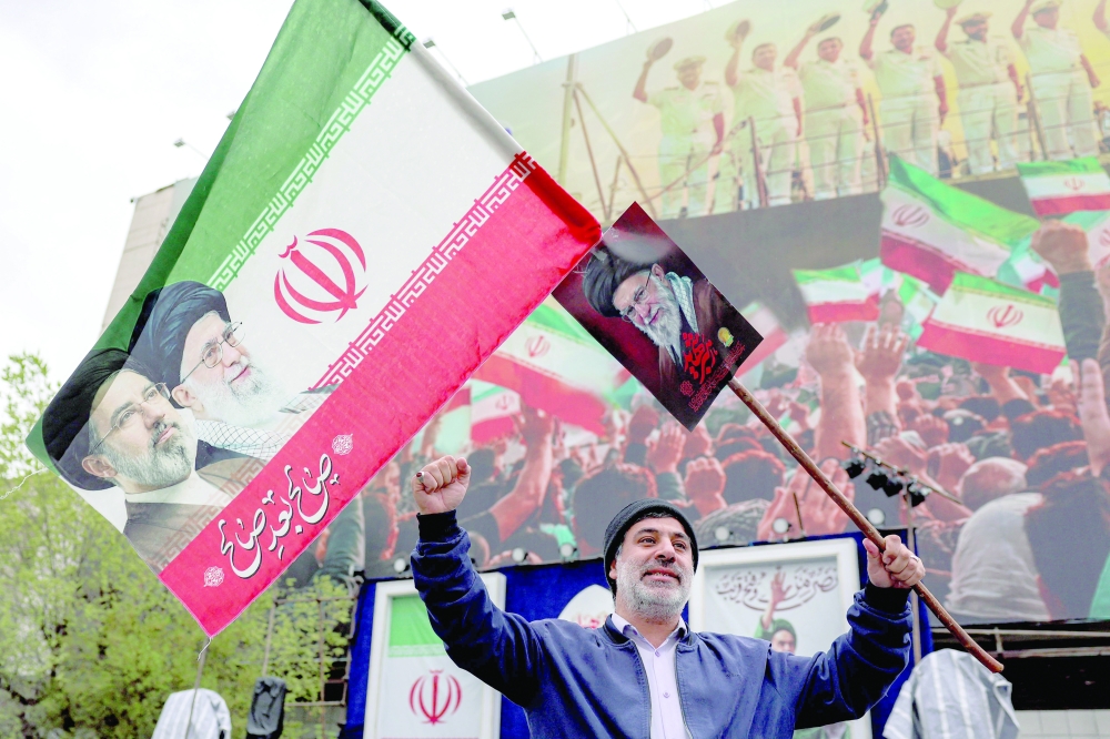 A man holds an Iranian flag along Enghelab Square in central Tehran. — AFP