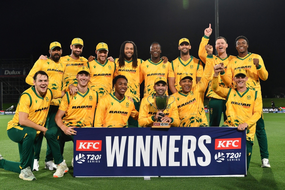 South Africa's Keshav Maharaj (front 3rd R) holds the series trophy as he and his teammates pose  