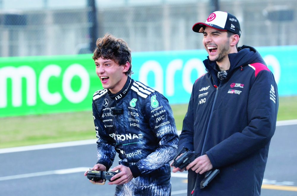 Mercedes' Andrea Kimi Antonelli plays with a remote control car as Haas' Esteban Ocon reacts ahead of the Japanese Grand Prix. — Reuters