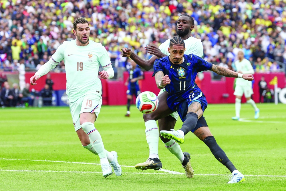 Brazil midfielder Raphinha (11) lets go with a shot past France defender Theo Hernandez (19) during the first half at Gillette Stadium. — Imagn Images