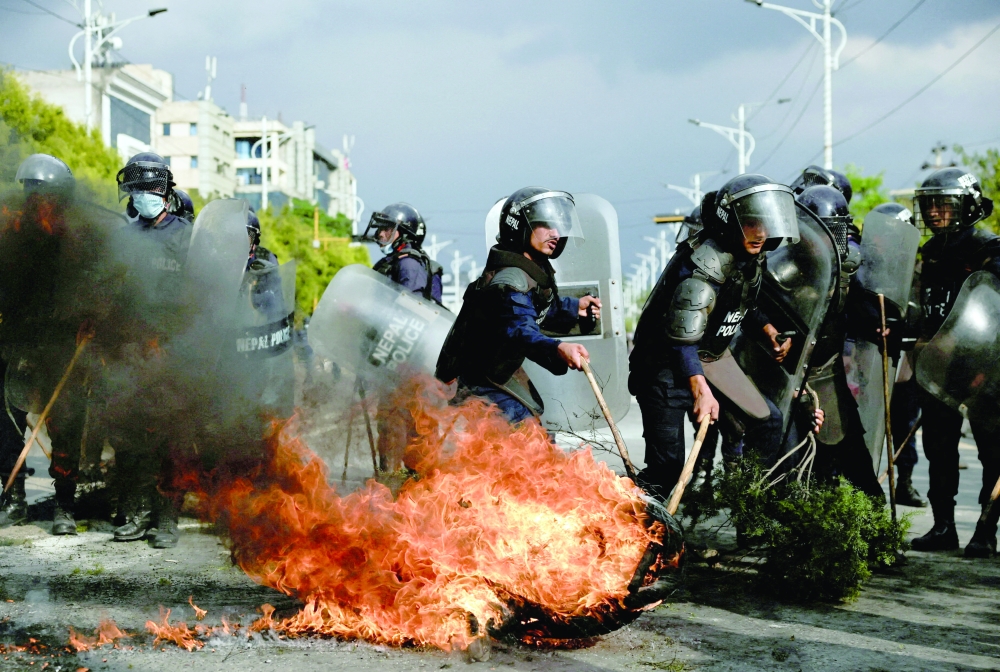 Police attempt to clear a flaming tyre during a protest by supporters of Nepal’s former PM Sharma Oli, in Kathmandu, Nepal. — Reuters 