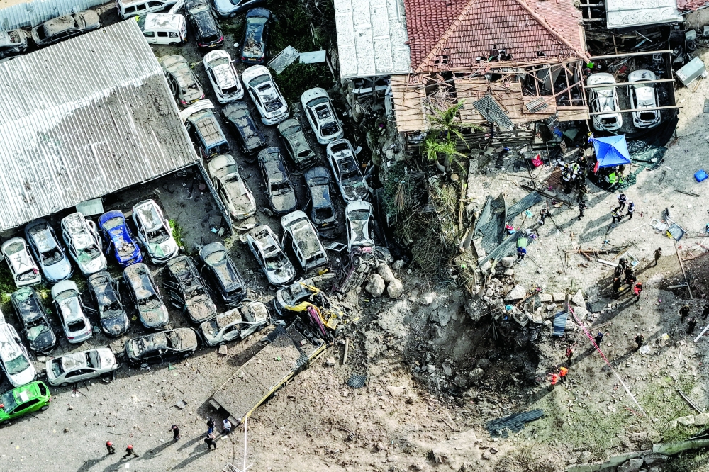 Israeli security work at the impact site following Iranian missile barrages, near Eshtaol, Israel. — Reuters