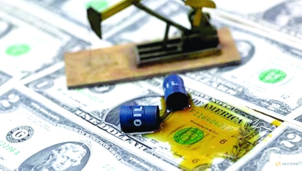 Oil, miniatures of oil barrels, oil pump jack and US dollar banknote are seen in this illustration. — Reuters