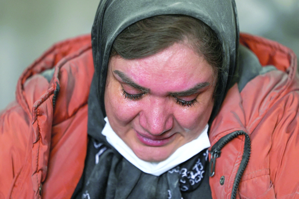 A woman reacts inside her brother's home, which was damaged by a strike, in Tehran, Iran, on Monday. - Reuters