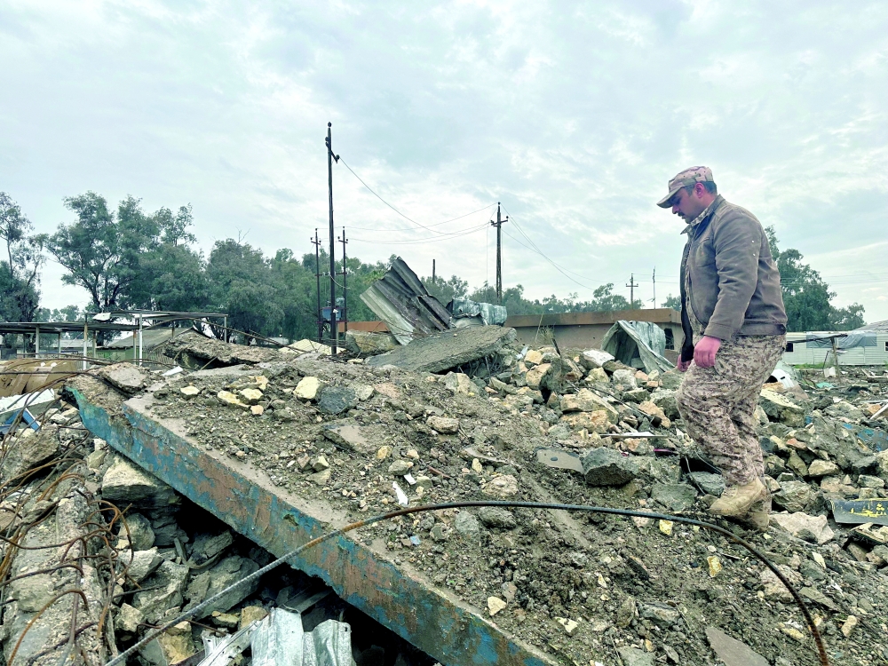 An Iraqi soldier inspects the site of an airstrike at a military medical clinic, where Iraqi security sources said several soldiers were killed and wounded, in western Anbar province, Iraq, March 26, 2026. Picture taken using a mobile phone. REUTERS/Osama Al-Dulaimi     TPX IMAGES OF THE DAY