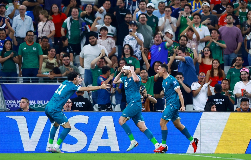  Iraq's Aymen Hussein celebrates scoring their second goal with teammates 