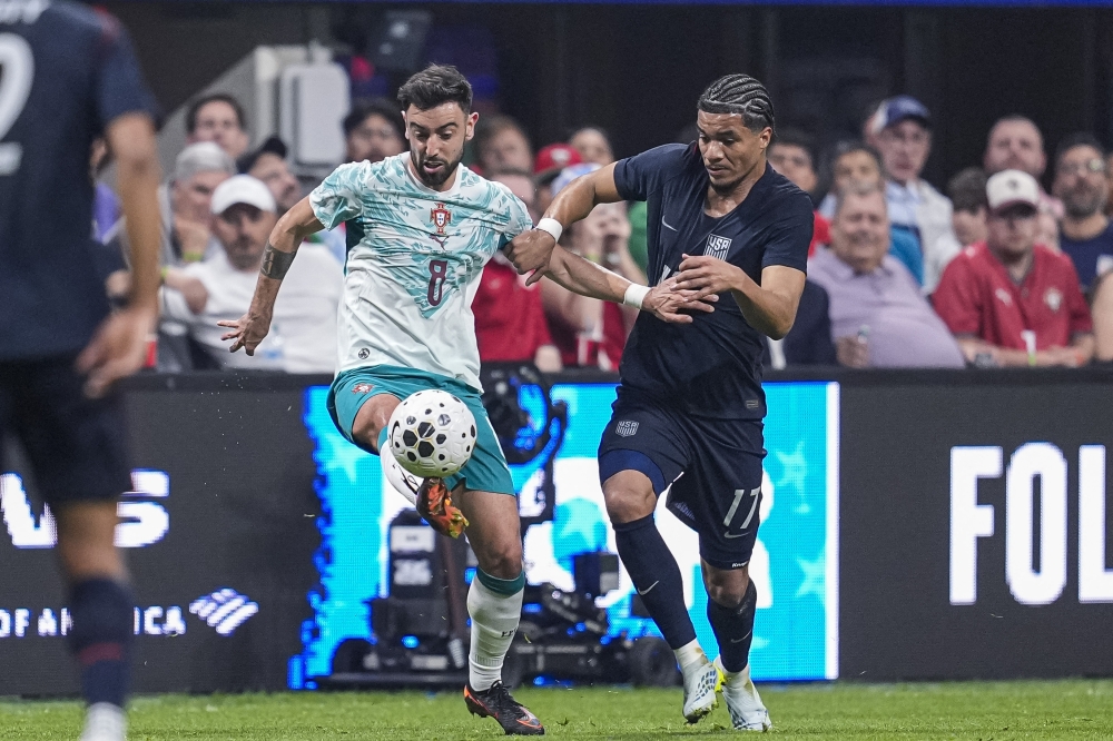 Portugal midfielder Bruno Fernandes(8) kicks the ball in front of United States midfielder Malik Tillman(17)  
