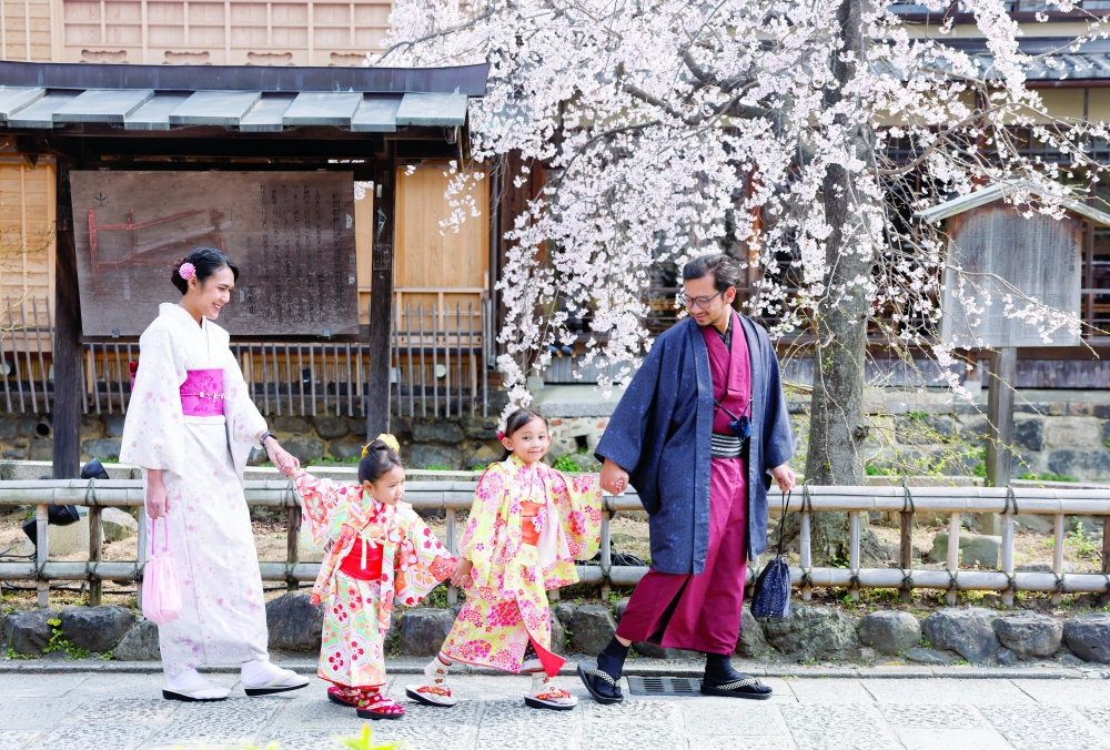 Tourists from abroad wearing kimonos pose for a souvenir photo with cherry blossoms in Kyoto, Japan, March 28, 2026. REUTERS/Manami Yamada