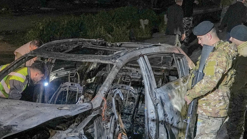Emergency personnel operate around a burned car following a targeted Israeli strike, in Khaldeh, Lebanon. — Reuters