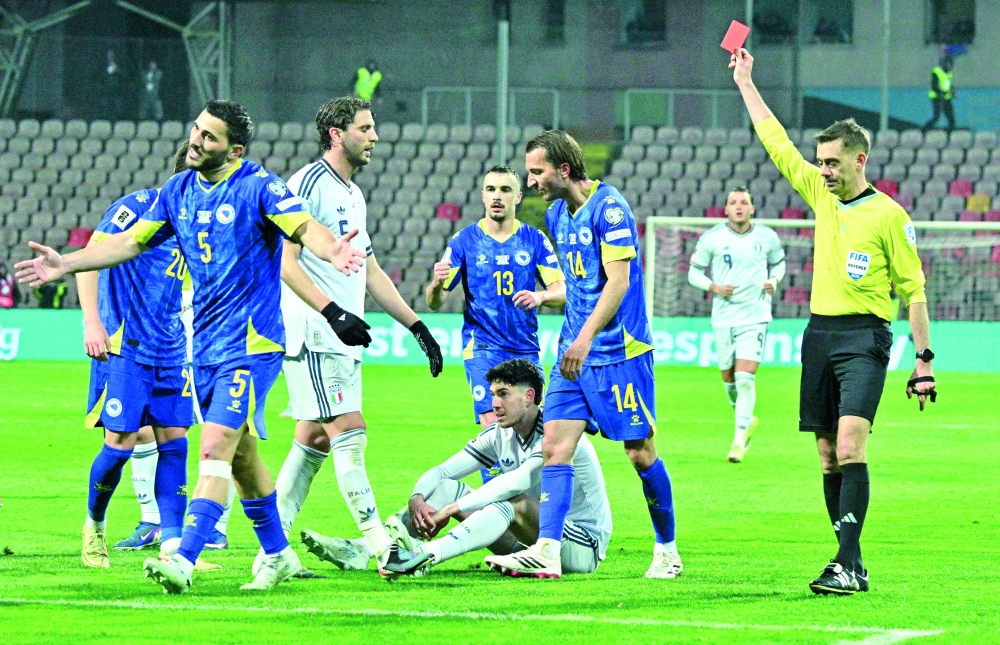 Italy's defender #21 Alessandro Bastoni (C, bottom) receives a red card from French referee Clement Turpin during the FIFA World Cup 2026 European qualification final football match between Bosnia-Herzegovina and Italy at the Bilino-Polje stadium in Zenica on March 31, 2026.  (Photo by Elvis BARUKCIC / AFP)
