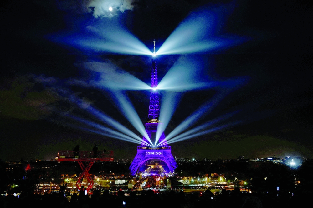 The Eiffel Tower lights up to mark the announcement of concert dates and ticket sales for singer Celine Dion's upcoming ten concerts in September and October in Paris, France, March 30, 2026. REUTERS/Benoit Tessier