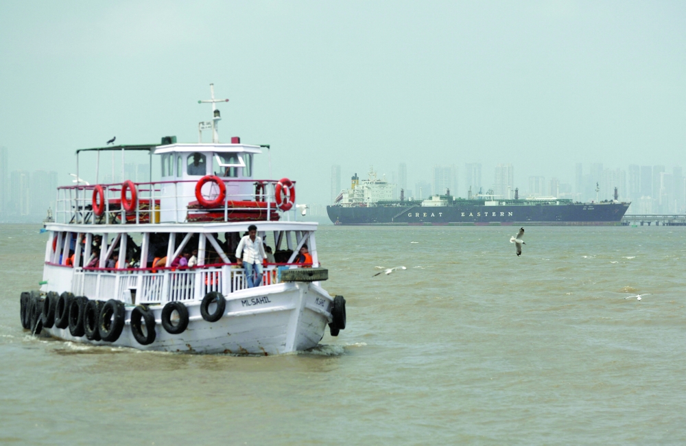 A ferry moves past the vessel Jag Vasant as it transfers LPG at a port in Mumbai, following its transit through the Strait of Hormuz amidst supply disruptions linked to the US-Israeli conflict. — Reuters