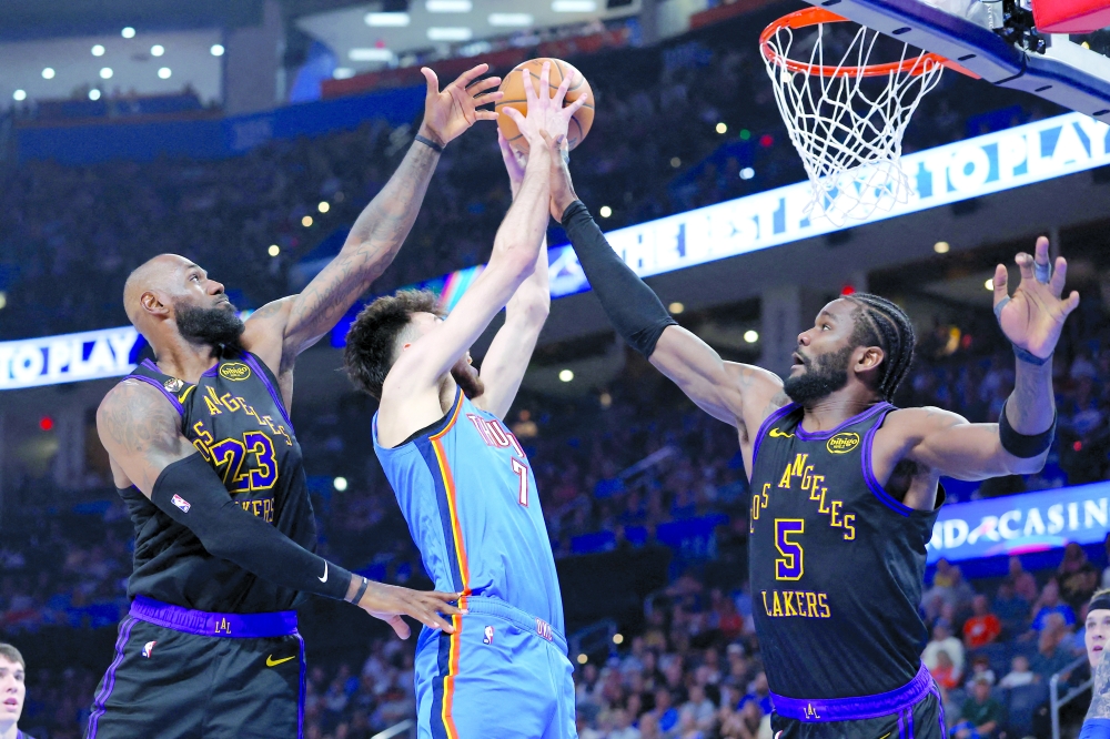 Oklahoma City Thunder center Chet Holmgren (7) goes up for a basket between Los Angeles Lakers forward LeBron James (23) and center Deandre Ayton (5) during the second half at Paycom Center. Mandatory Credit: Alonzo Adams-Imagn Images