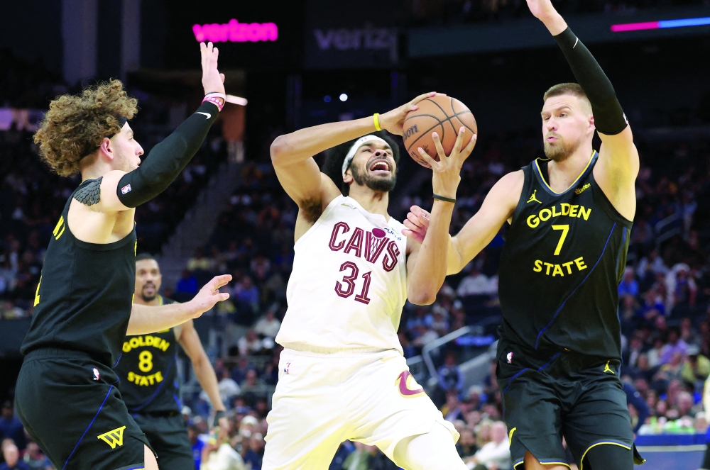 Cleveland Cavaliers center Jarrett Allen (31) drives in between Golden State Warriors guard Brandin Podziemski (2) and forward/center Kristaps Porzingis (7) during the fourth quarter at Chase Center. Mandatory Credit: Kelley L Cox-Imagn Images
