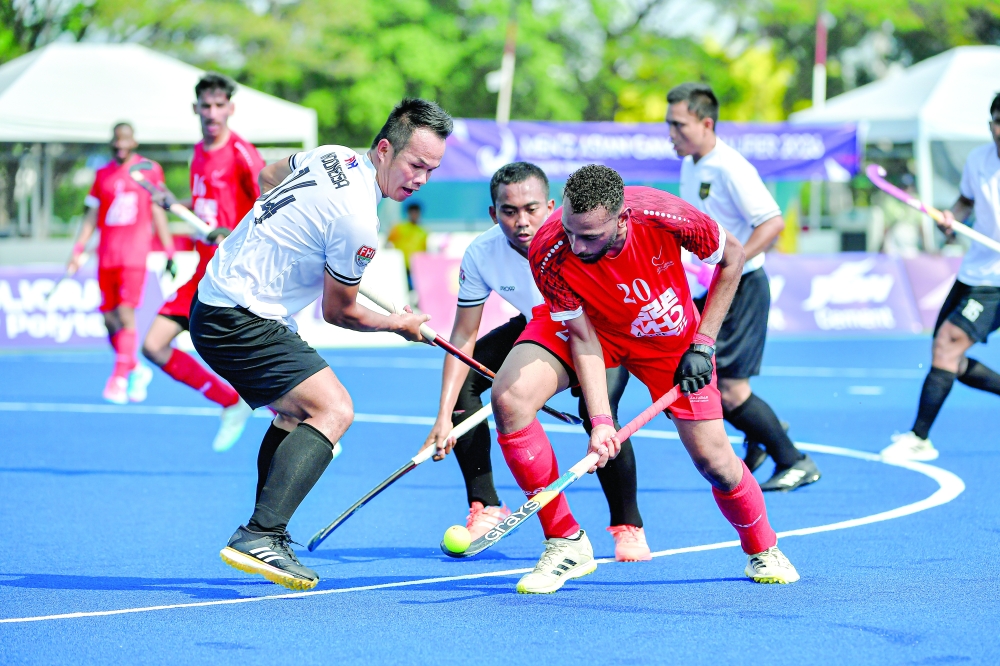 Oman and Indonesia players fight for the ball during the Asian Games Qualifier in Bangkok.