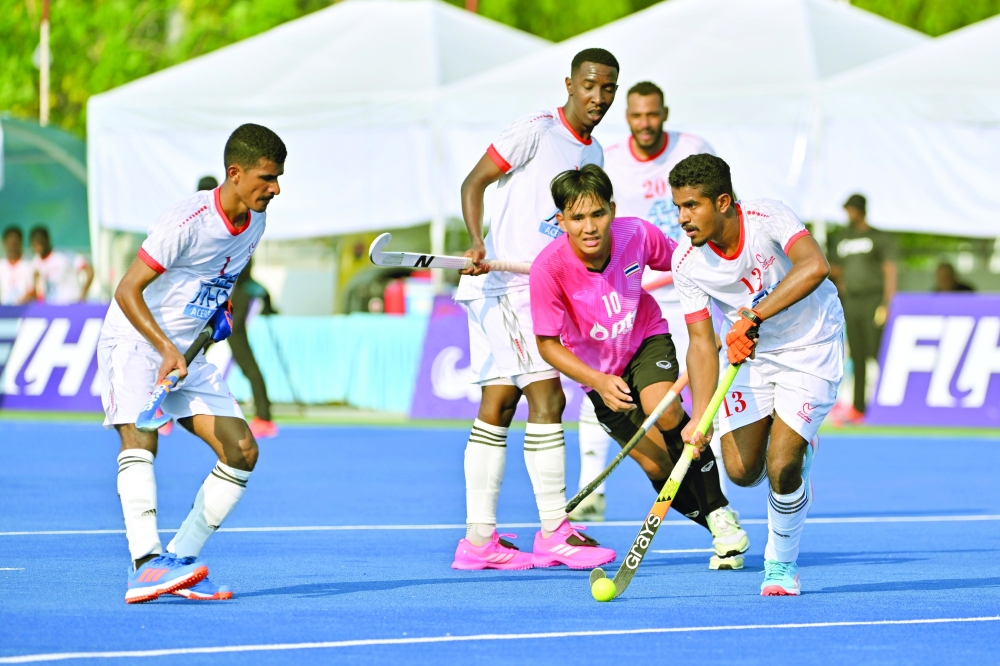 Oman player drives forward under Thai pressure during the Group A clash in Bangkok.