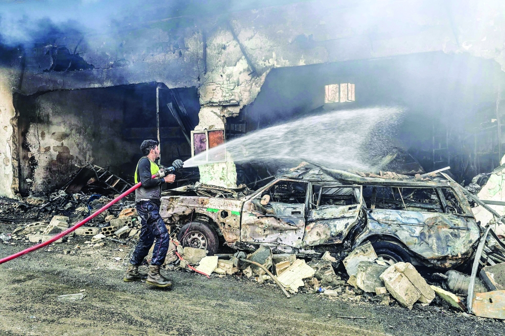 A firefighter extinguishes a fire at the site of an Israeli air strike in the southern Lebanese village of Hanouiyeh, east of Tyre, on March 30, 2026.  Israel renewed its bombardment of Beirut's southern suburbs on March 30 while continuing air strikes on Lebanon's south, one of which targeted an army checkpoint and killed a soldier. Lebanon was pulled into the Middle East conflict when Tehran-backed armed group Hezbollah fired rockets at Israel on March 2 in revenge for the killing of Iran's supreme leader, the opening salvo in the US-Israeli war against the Islamic republic. (Photo by KAWNAT HAJU / AFP)